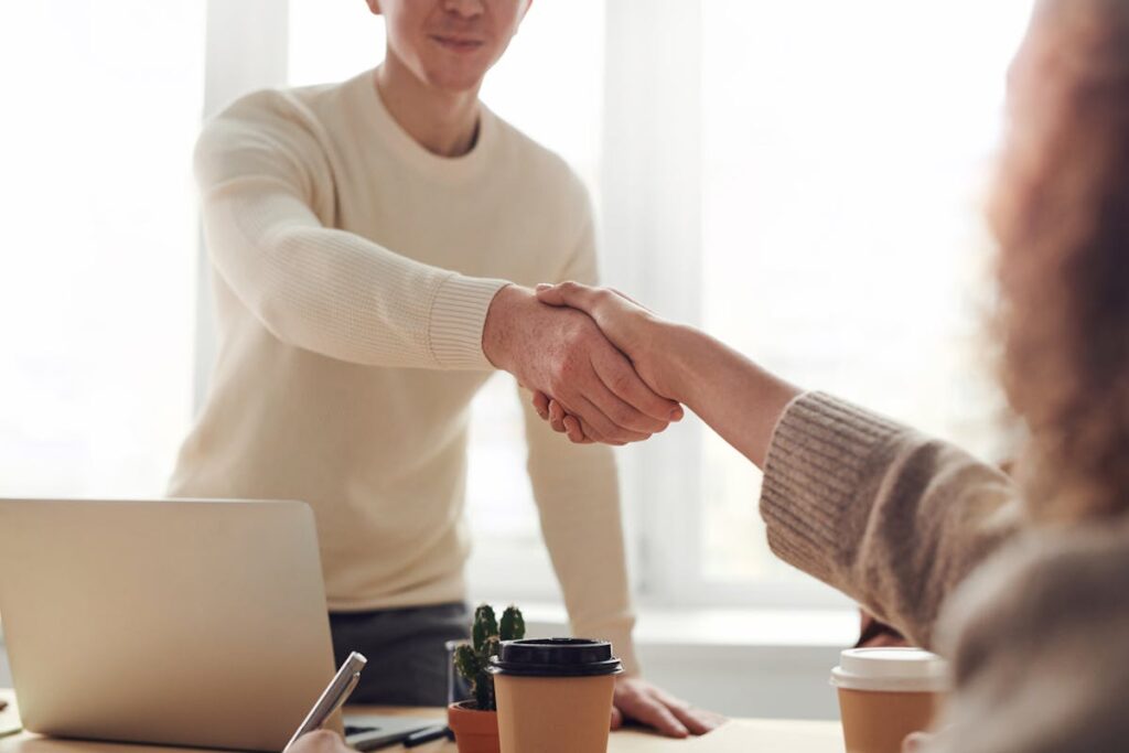 Professional insurance broker shaking hands with client in Houston TX